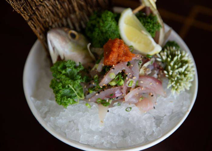 A fresh serving of seki-aji horse mackerel sashimi, resting on a bed of ice.